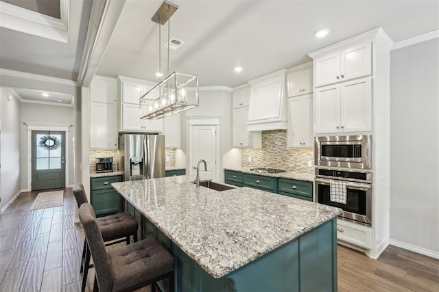 8400 Poplar Dr, Edmond, OK 73034 - kitchen featuring appliances with stainless steel finishes, crown molding, white cabinets, light wood-style flooring, and tasteful backsplash