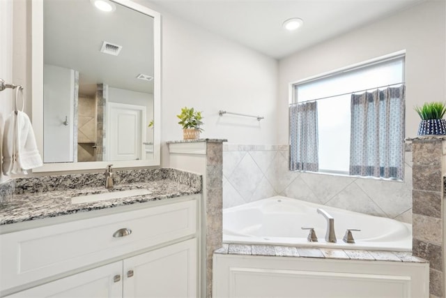 8400 Poplar Dr, Edmond, OK 73034 - bathroom with vanity, a garden tub, and recessed lighting
