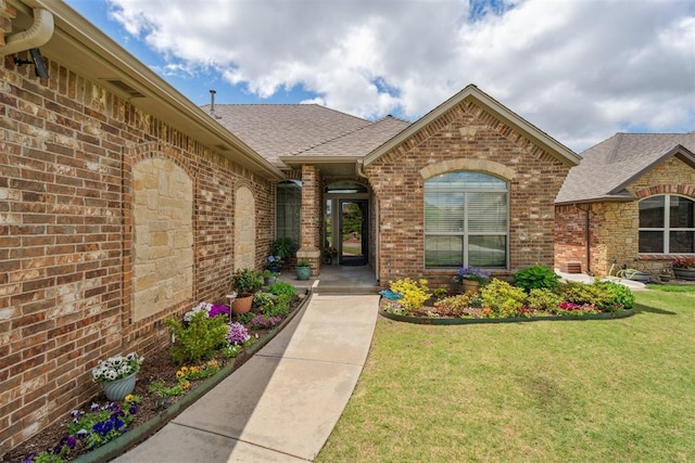 12812 NW 6th St, Yukon, OK 73099 - entrance to property with a shingled roof, brick siding, and a lawn