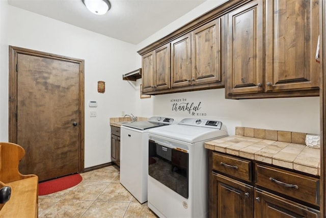 12812 NW 6th St, Yukon, OK 73099 - laundry area featuring cabinet space, washer and clothes dryer, and light tile patterned floors