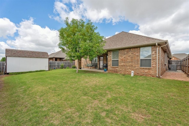 12812 NW 6th St, Yukon, OK 73099 - rear view of house featuring a patio area, brick siding, central air condition unit, a shingled roof, and an outdoor structure