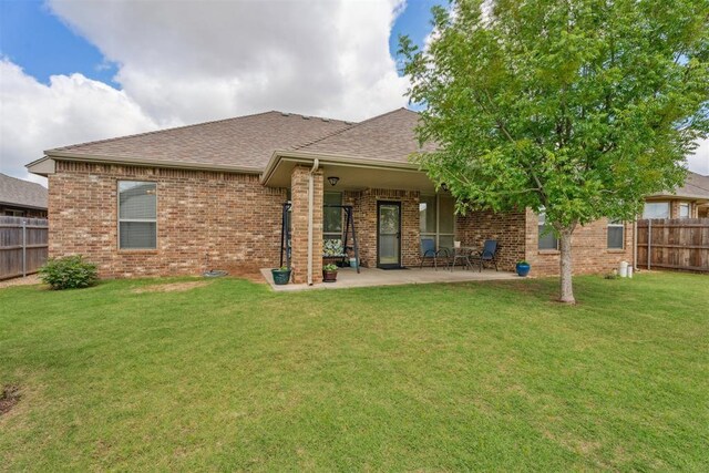 12812 NW 6th St, Yukon, OK 73099 - back of house featuring brick siding, a shingled roof, and a patio