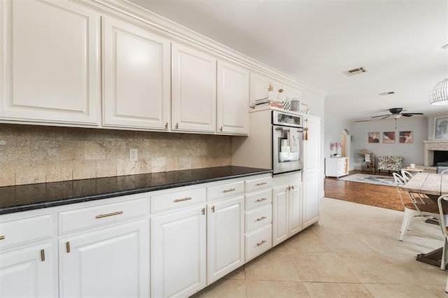 2728 Kerry Ln, Oklahoma City, OK 73120 - kitchen with oven, ceiling fan, backsplash, and open floor plan