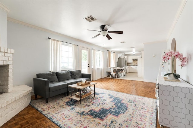 2728 Kerry Ln, Oklahoma City, OK 73120 - living area featuring crown molding, a ceiling fan, a brick fireplace, and arched walkways