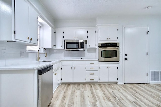 2528 Oakridge Dr, Bethany, OK 73008 - kitchen featuring stainless steel appliances, a sink, white cabinets, and tasteful backsplash