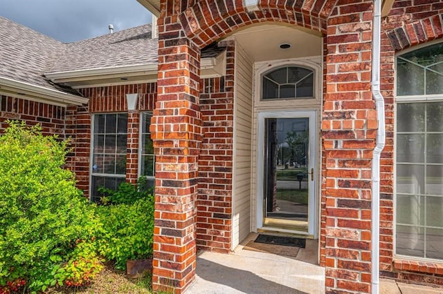 2105 SW 124th St, Oklahoma City, OK 73170 - doorway to property featuring brick siding and a shingled roof