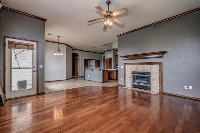 2105 SW 124th St, Oklahoma City, OK 73170 - unfurnished living room with crown molding, light wood-style flooring, ceiling fan, arched walkways, and baseboards