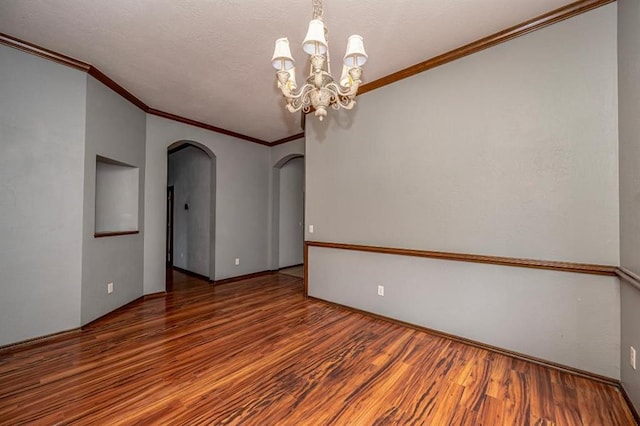 2105 SW 124th St, Oklahoma City, OK 73170 - unfurnished room featuring arched walkways, wood finished floors, crown molding, and a chandelier