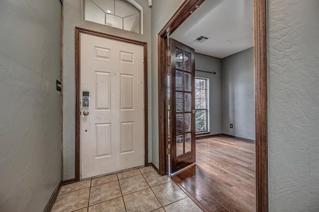 2105 SW 124th St, Oklahoma City, OK 73170 - foyer featuring a textured wall, baseboards, light tile patterned floors, and french doors