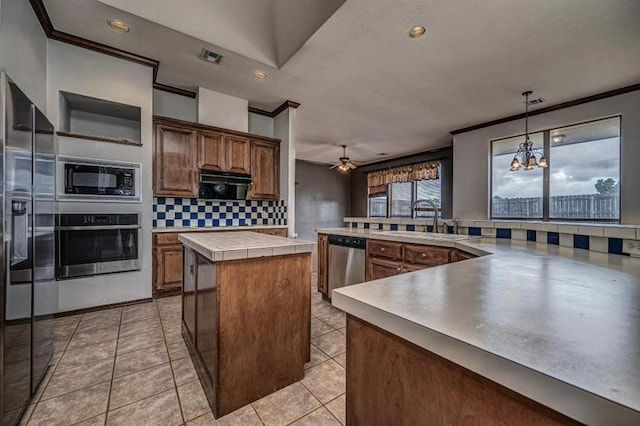 2105 SW 124th St, Oklahoma City, OK 73170 - kitchen with appliances with stainless steel finishes, a sink, a large island, tasteful backsplash, and ornamental molding