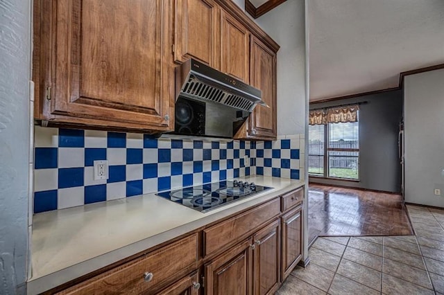 2105 SW 124th St, Oklahoma City, OK 73170 - kitchen with black electric cooktop, decorative backsplash, crown molding, exhaust hood, and light countertops