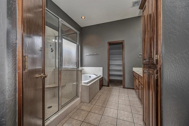 2105 SW 124th St, Oklahoma City, OK 73170 - full bathroom featuring a stall shower, a bath, tile patterned flooring, vanity, and a textured wall
