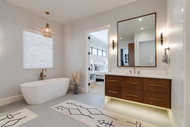 909 NW 156th St, Edmond, OK 73013 - ensuite bathroom featuring vanity, a soaking tub, baseboards, and recessed lighting