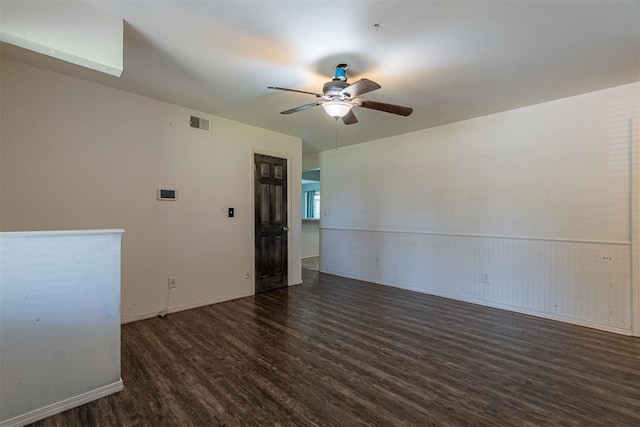 spare room featuring wood finished floors, a ceiling fan, and baseboards