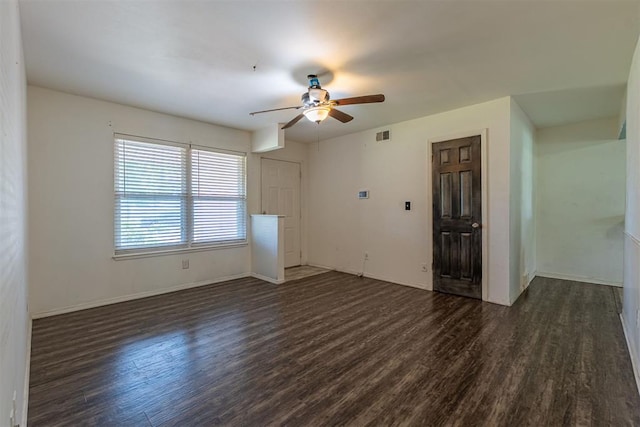 unfurnished living room with dark wood finished floors, ceiling fan, and baseboards