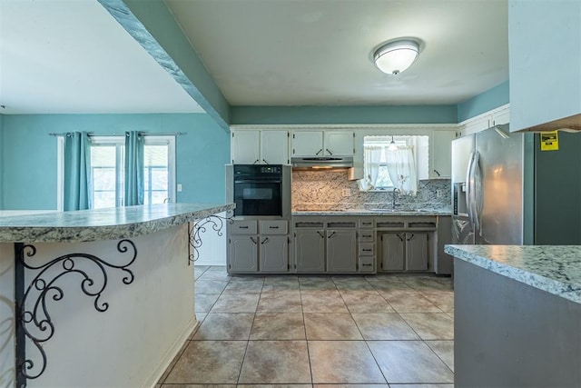 kitchen featuring black appliances, tasteful backsplash, healthy amount of natural light, and light countertops