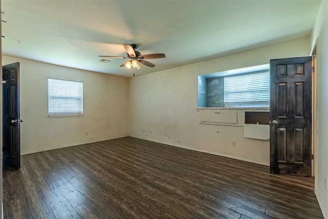 spare room featuring wood finished floors, a ceiling fan, and baseboards