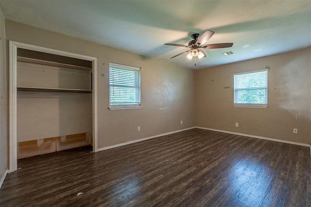 unfurnished bedroom with multiple windows, wood finished floors, and a closet