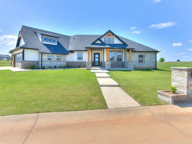 4850 Ranchero Dr, Edmond, OK 73025 - view of front facade featuring stone siding, roof with shingles, a front lawn, concrete driveway, and a garage