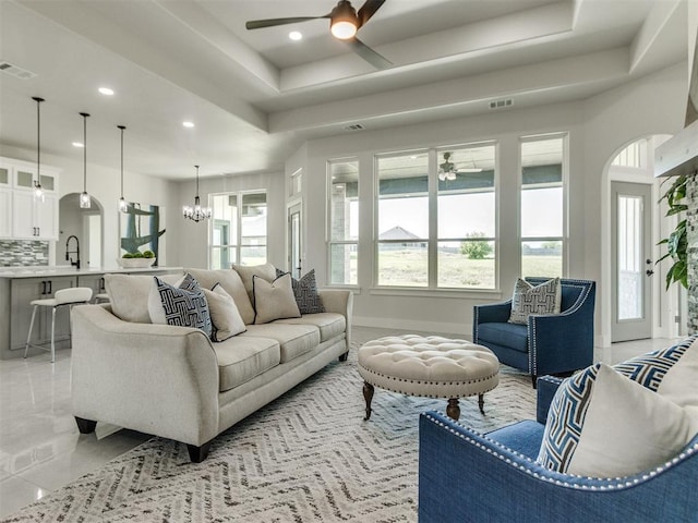 4850 Ranchero Dr, Edmond, OK 73025 - living area featuring a ceiling fan, recessed lighting, a chandelier, a raised ceiling, and arched walkways