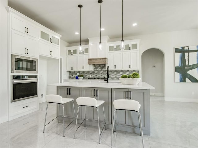 4850 Ranchero Dr, Edmond, OK 73025 - kitchen with stainless steel appliances, arched walkways, backsplash, light countertops, and recessed lighting