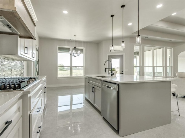 4850 Ranchero Dr, Edmond, OK 73025 - kitchen with appliances with stainless steel finishes, a sink, tasteful backsplash, wall chimney range hood, and light countertops