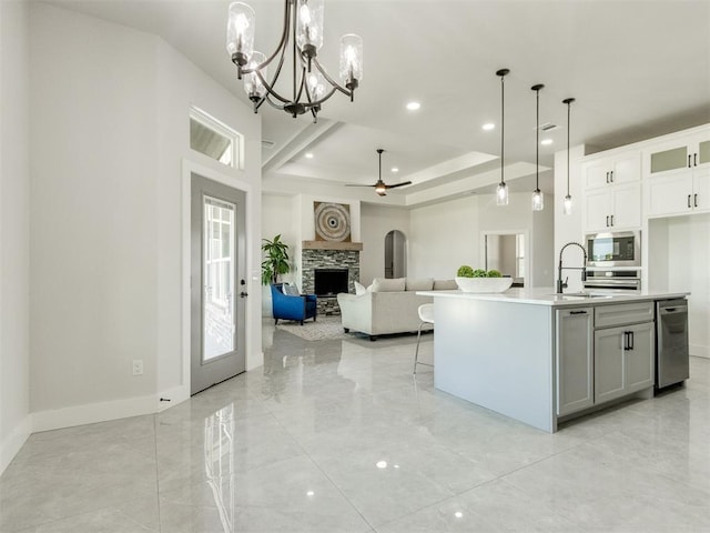 4850 Ranchero Dr, Edmond, OK 73025 - kitchen with a sink, appliances with stainless steel finishes, light countertops, a fireplace, and open floor plan