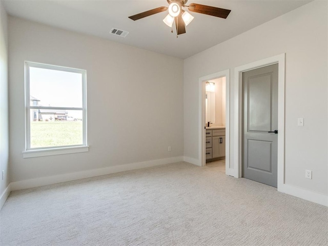 4850 Ranchero Dr, Edmond, OK 73025 - unfurnished bedroom featuring baseboards, light colored carpet, ensuite bathroom, and ceiling fan