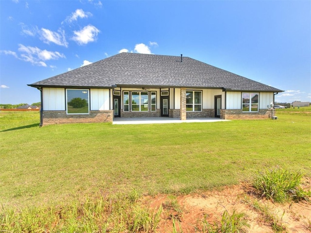 4850 Ranchero Dr, Edmond, OK 73025 - back of house featuring a patio area, board and batten siding, a yard, roof with shingles, and brick siding