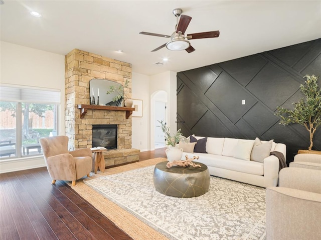 living area featuring dark wood-style flooring, arched walkways, ceiling fan, baseboards, and recessed lighting
