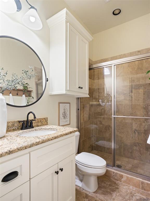 full bath with a shower stall, toilet, and vanity