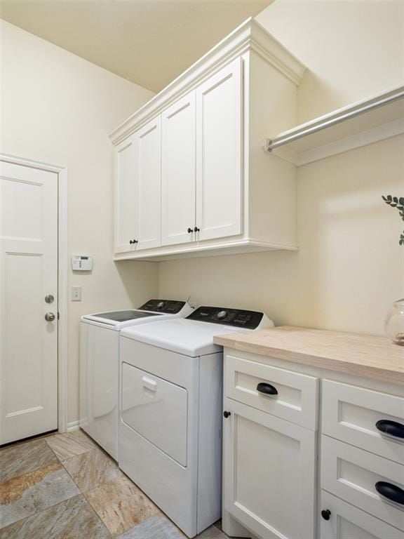 clothes washing area featuring cabinet space and independent washer and dryer