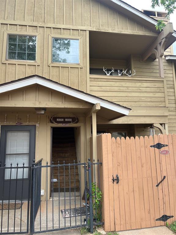 view of exterior entry featuring a gate, fence, and board and batten siding