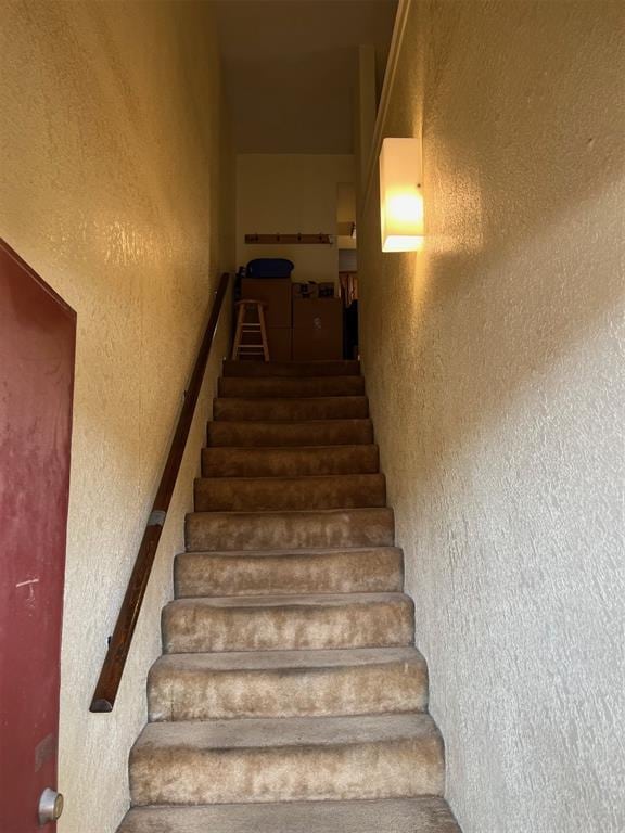 stairway featuring a textured wall