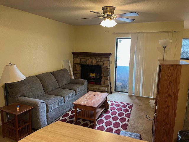 carpeted living room with a ceiling fan and a fireplace