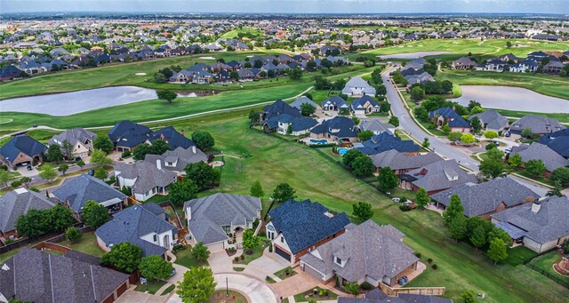 aerial view of property and surrounding area featuring nearby suburban area and a large body of water
