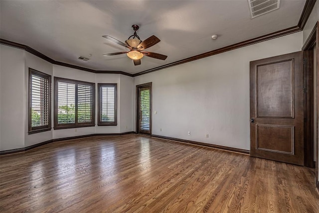 empty room with wood finished floors, a ceiling fan, baseboards, and ornamental molding