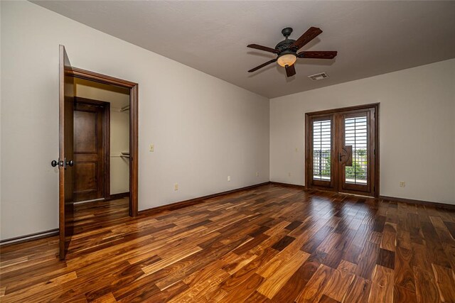 spare room featuring wood finished floors, a ceiling fan, and baseboards