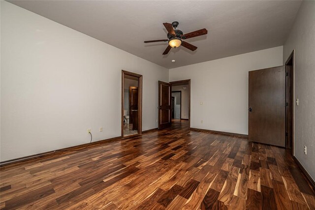 unfurnished room featuring dark wood finished floors, ceiling fan, and baseboards