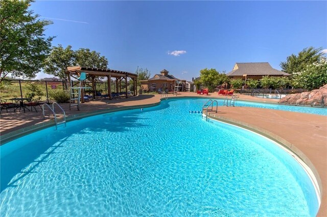 community pool featuring fence, a patio, and a gazebo