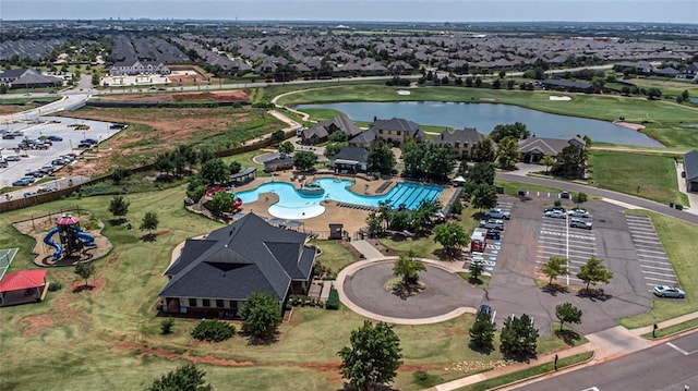 view of property location featuring a large body of water, a pool, and nearby suburban area