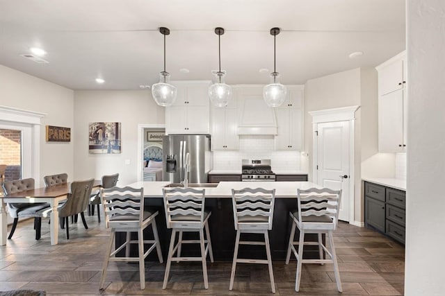 9117 NW 123rd St, Yukon, OK 73099 - kitchen featuring stainless steel appliances, dark wood-type flooring, tasteful backsplash, light countertops, and an island with sink