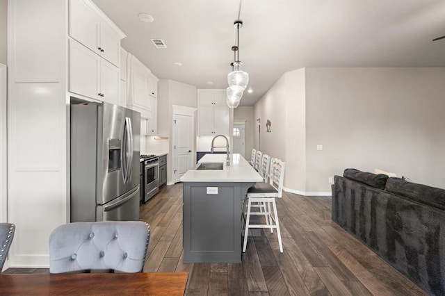 9117 NW 123rd St, Yukon, OK 73099 - kitchen featuring stainless steel appliances, a sink, dark wood-style flooring, and a kitchen island with sink