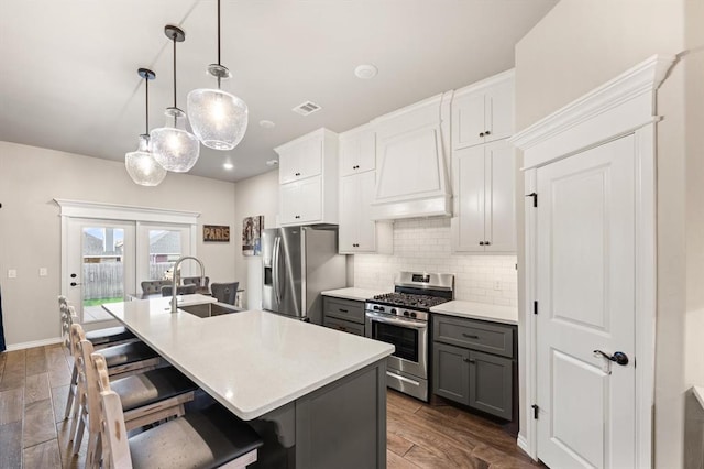 9117 NW 123rd St, Yukon, OK 73099 - kitchen featuring appliances with stainless steel finishes, a sink, gray cabinetry, backsplash, and a center island with sink