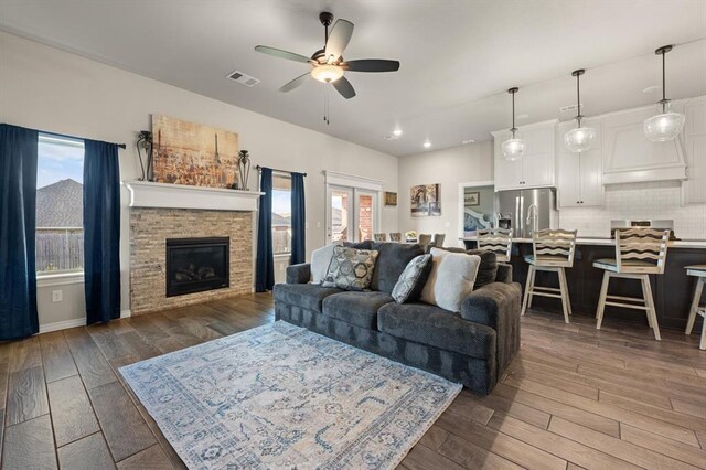 9117 NW 123rd St, Yukon, OK 73099 - living room featuring ceiling fan, dark wood-style flooring, a stone fireplace, and recessed lighting