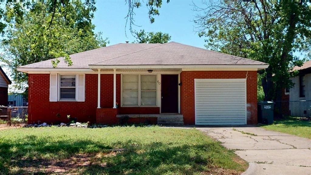 40 E 14th St, Edmond, OK 73034 - ranch-style house featuring entry steps, brick siding, a shingled roof, and concrete driveway