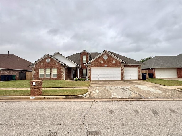 view of front of home featuring brick siding, a front yard, driveway, and a garage