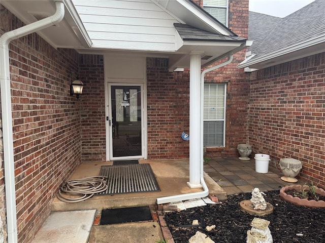 view of exterior entry with brick siding
