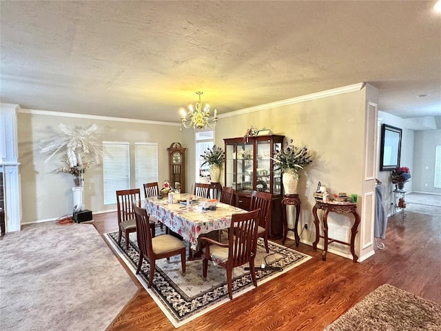 dining space featuring a chandelier, baseboards, wood finished floors, a textured ceiling, and ornamental molding
