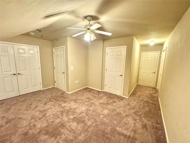 unfurnished bedroom featuring carpet, a textured ceiling, a ceiling fan, a closet, and baseboards